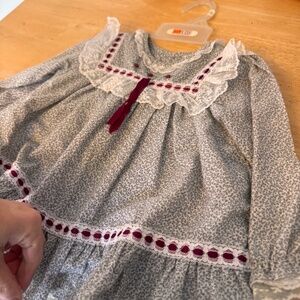 This elegant kids dress features a charming gray and white pattern with delicate
